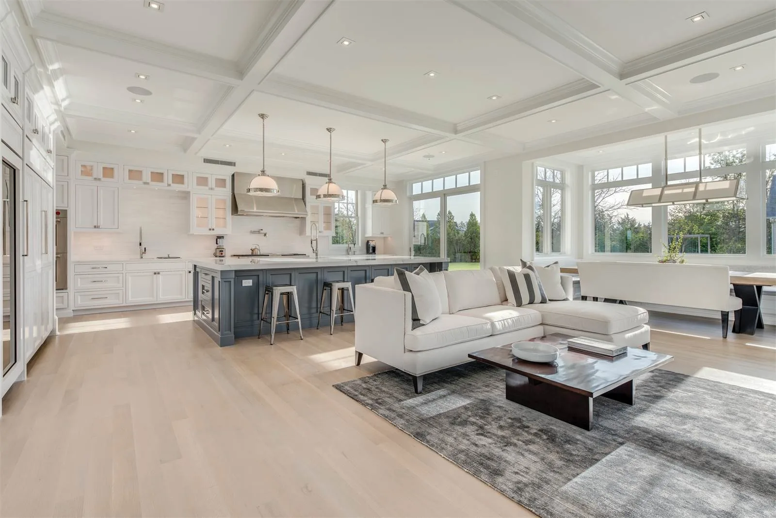 Cuisine ouverte sur salon style Hamptons avec cabinetry blanc et parquet