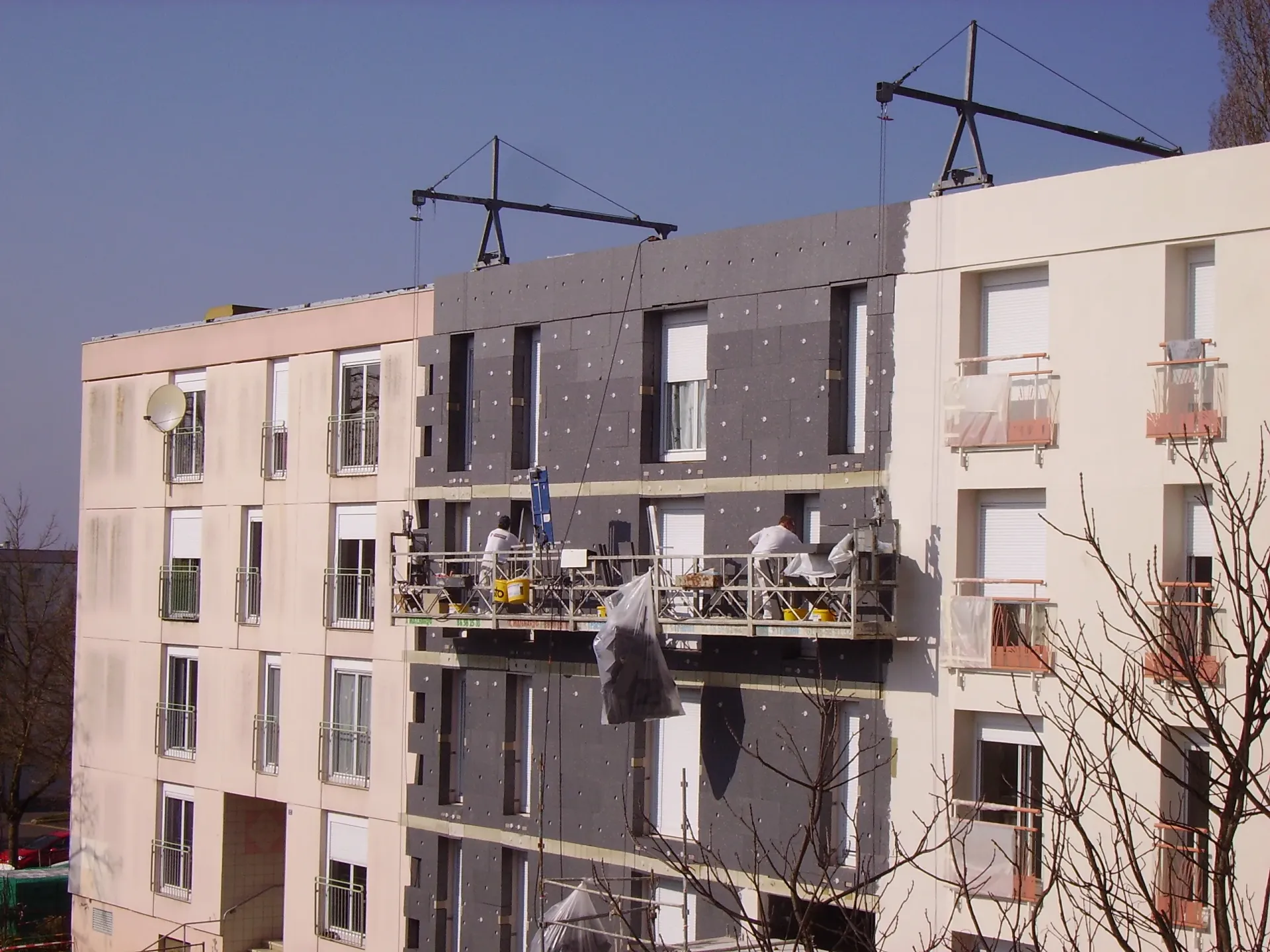 Travaux d'isolation thermique par l'extérieur avec panneaux isolants sur façade de bâtiment