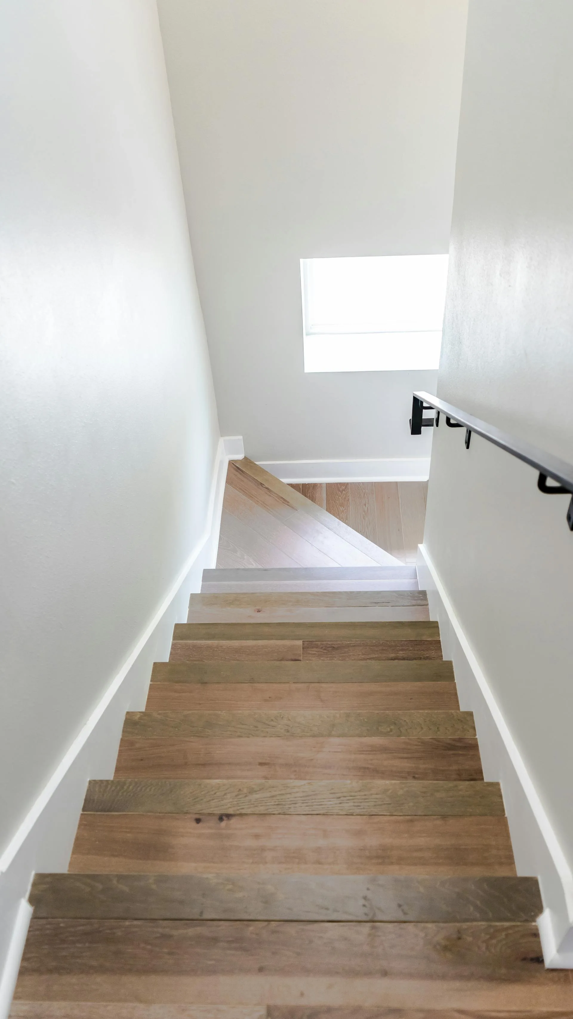 Détail de marches en bois dans un immeuble résidentiel, rampe et contremarches visibles