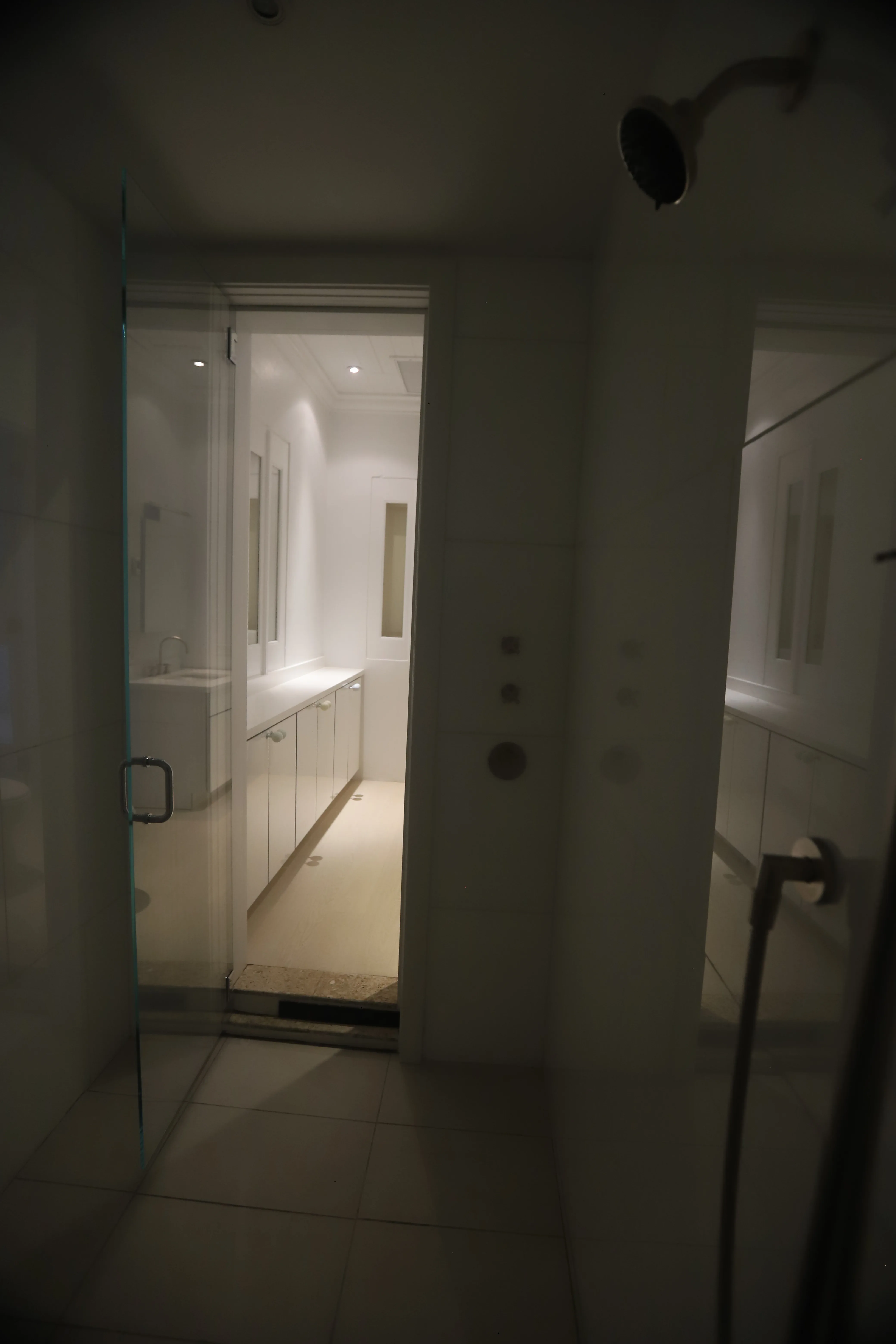 Douche moderne avec portes en verre et carrelage blanc épuré