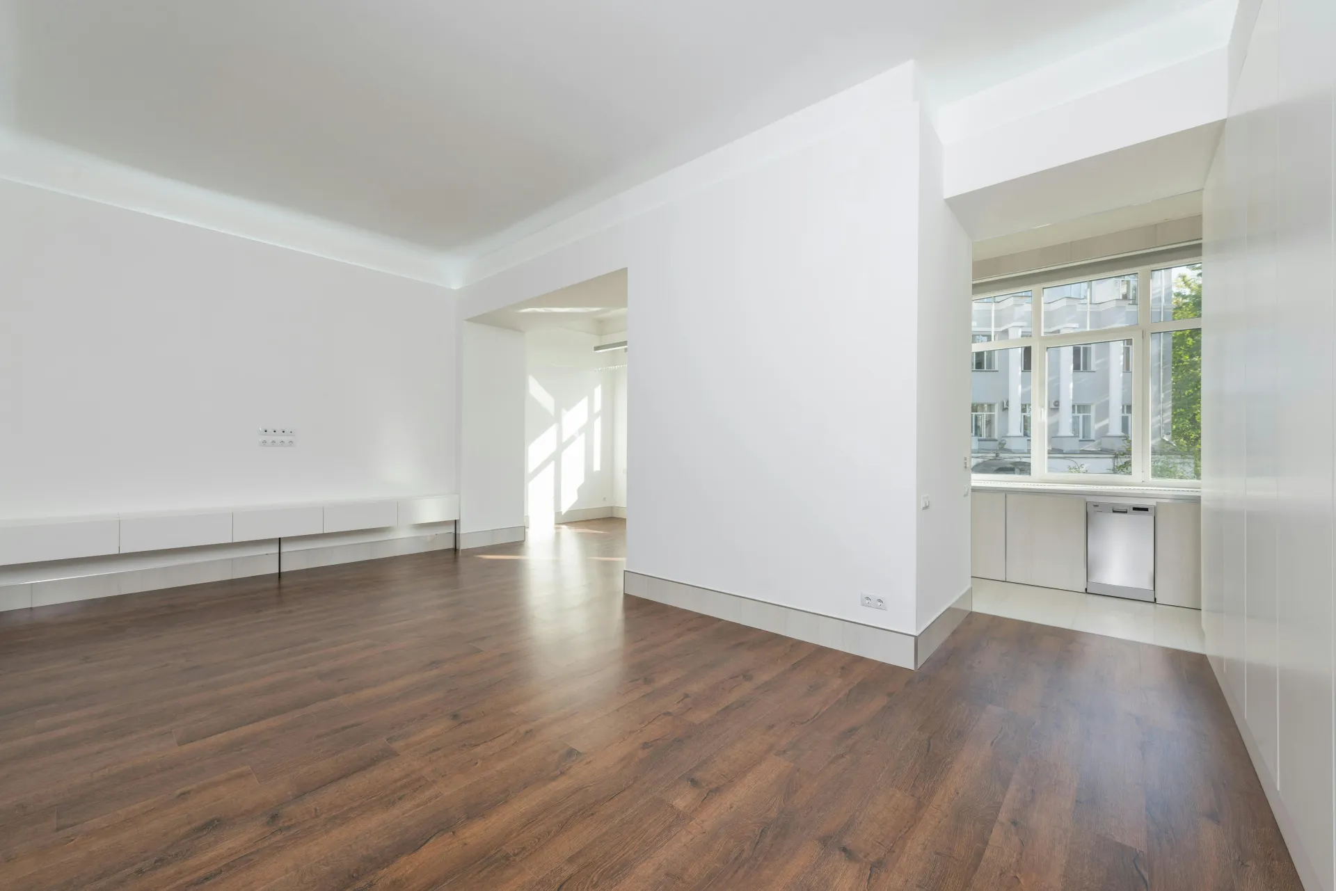 Appartement vide avec sol en vinyle aspect bois et murs blancs lumineux